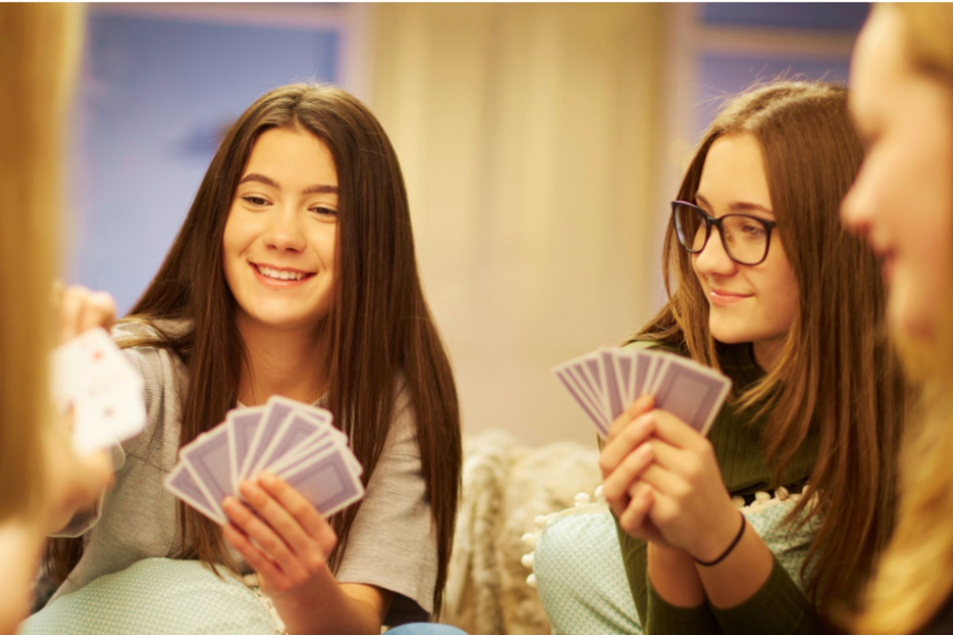 Adolescents jouant à un jeu de société de cartes, moment convivial et souriant entre amis