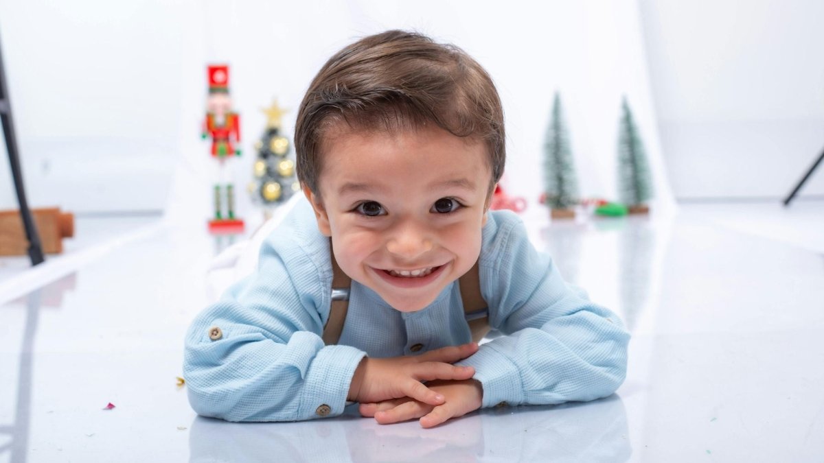 enfant souriant allongé sur le sol, illustrant la joie et la concentration lors d’un jeu éducatif adapté aux enfants HPI ou avec troubles de l’attention.