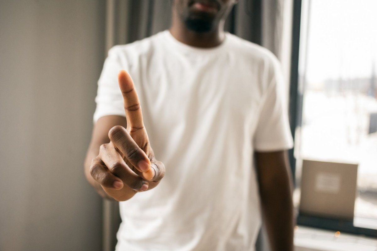 Homme levant l’index pour dire non, symbole de refus et de consentement
