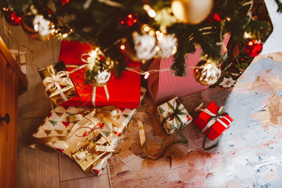 Cadeaux de Noël emballés sous un sapin décoré, ambiance festive et conviviale